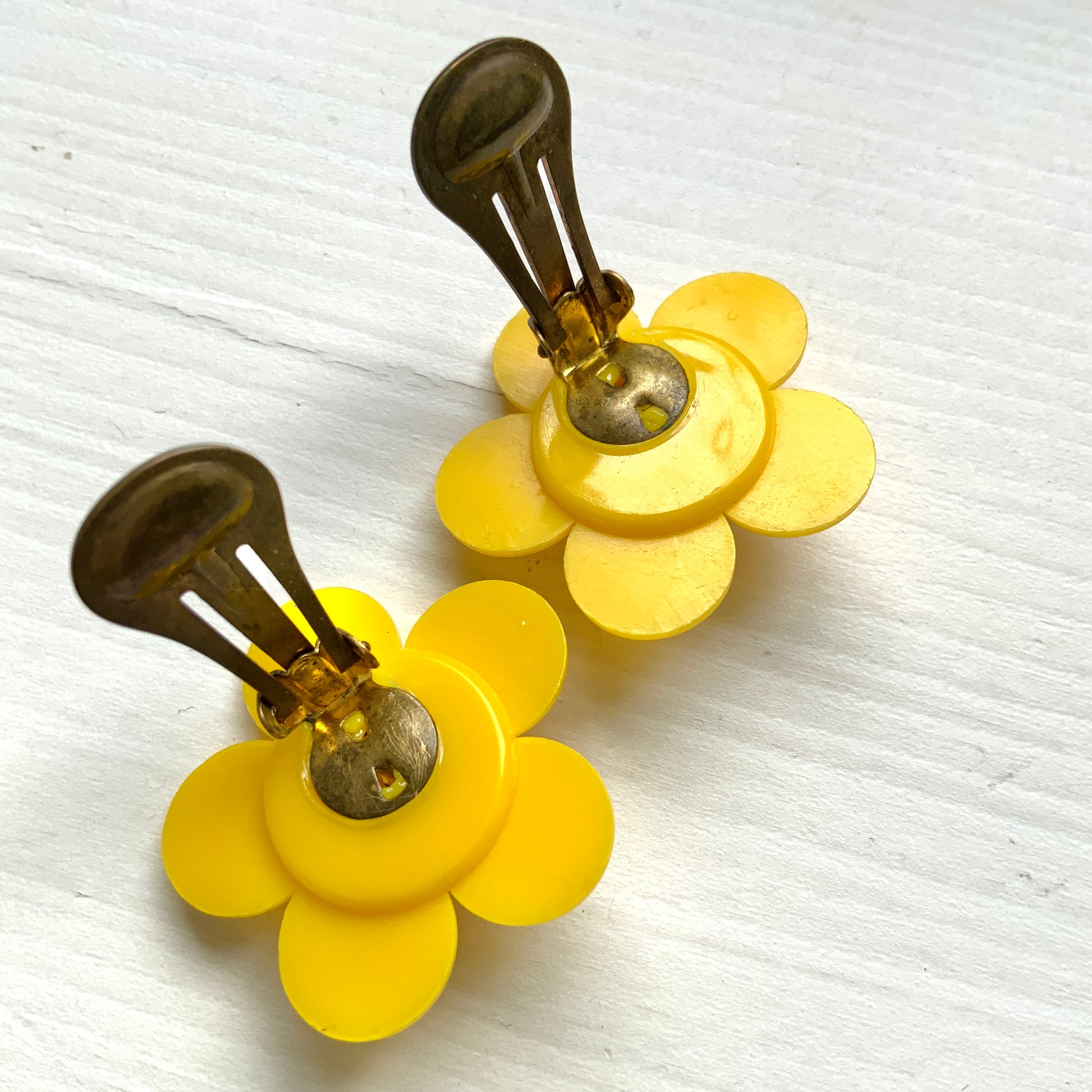 Flower clip-on earrings in a vivid buttery yellow tone.  バターのようなビビッドイエローのお花のクリップイヤリング。
