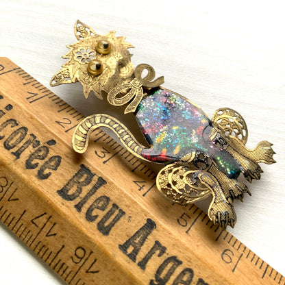 A vintage cat brooch featuring a vibrant rainbow enamel body. レインボーグリッターのボディが印象的な、ヴィンテージのキャットブローチ。