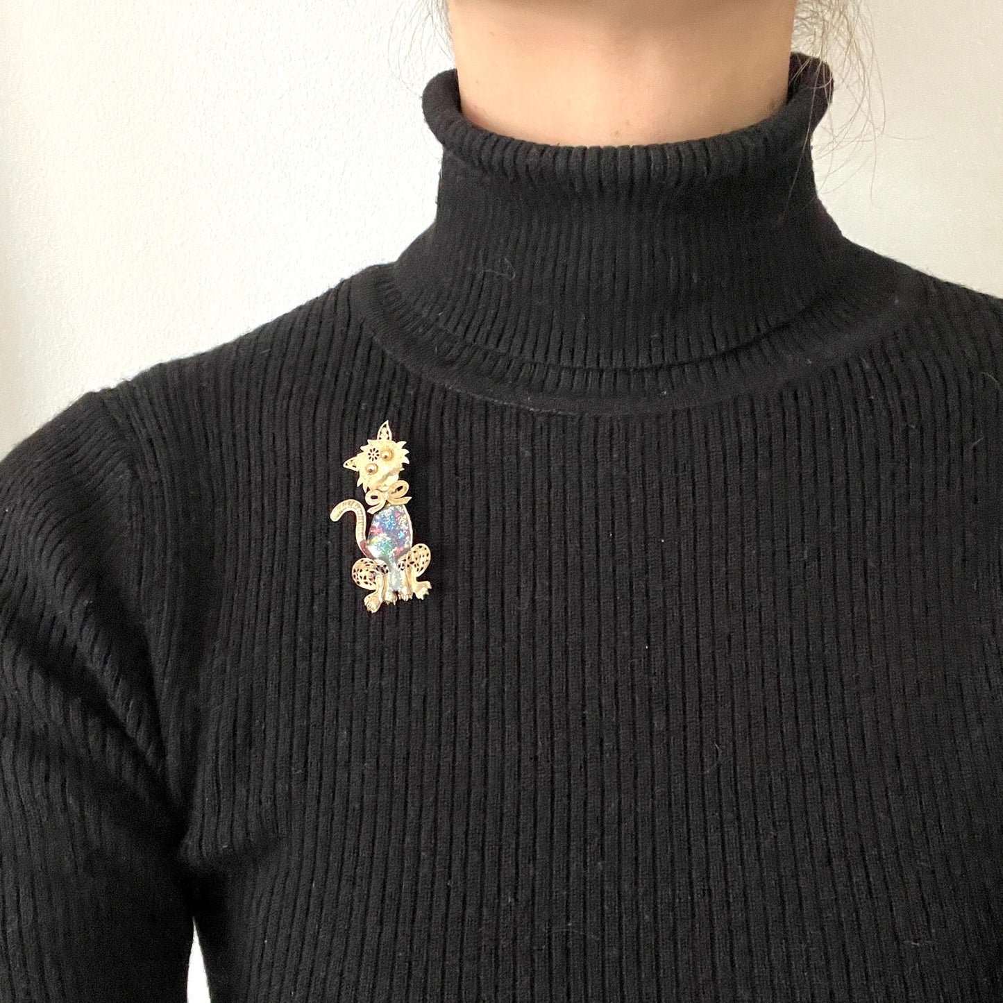 A vintage cat brooch featuring a vibrant rainbow enamel body. レインボーグリッターのボディが印象的な、ヴィンテージのキャットブローチ。