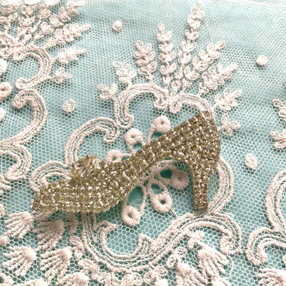 A vintage brooch shaped like a “glass slipper”, set with sparkling clear rhinestones throughout. ラインストーンがびっしりと敷き詰められた“ガラスの靴”のようなヴィンテージブローチ。 