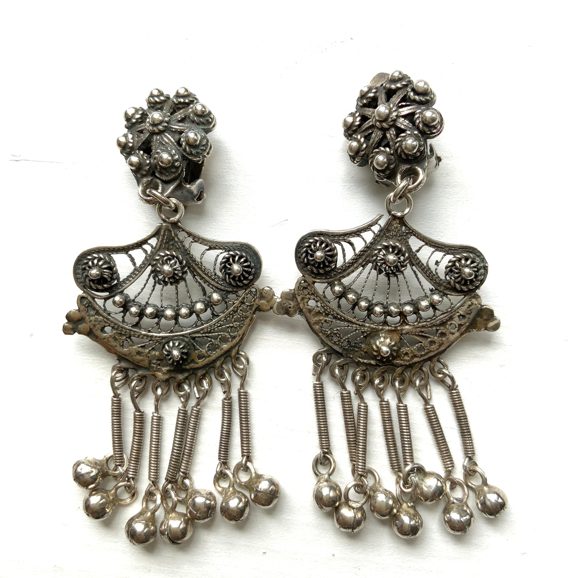 Silver filigree chandelier clip-on earrings with floral motifs and delicate openwork details.  シルバーのフィリグリー細工が施されたシャンデリア型クリップイヤリング。 