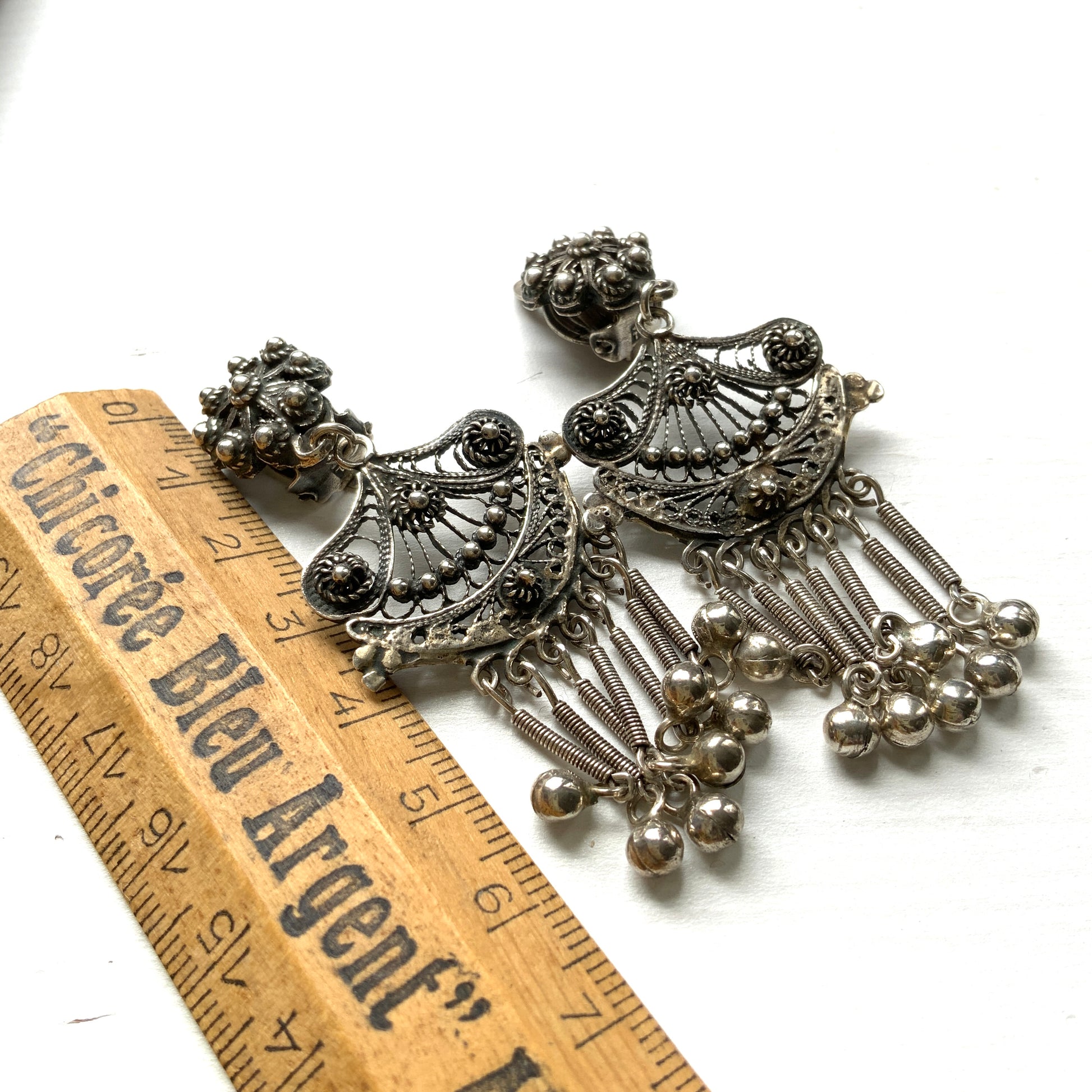 Silver filigree chandelier clip-on earrings with floral motifs and delicate openwork details.  シルバーのフィリグリー細工が施されたシャンデリア型クリップイヤリング。 