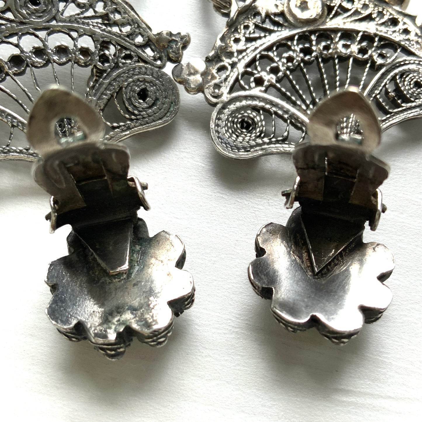 Silver filigree chandelier clip-on earrings with floral motifs and delicate openwork details.  シルバーのフィリグリー細工が施されたシャンデリア型クリップイヤリング。 