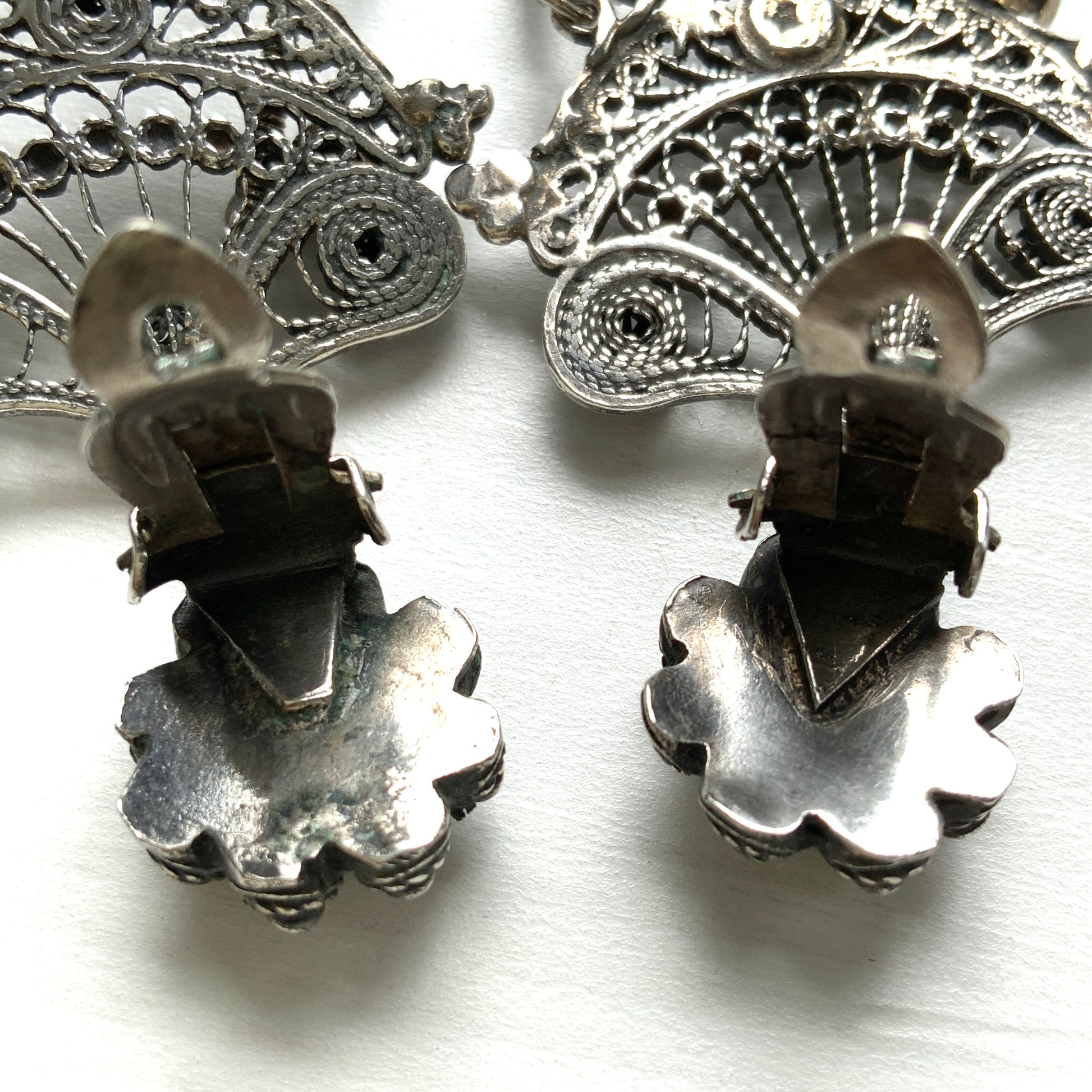 Silver filigree chandelier clip-on earrings with floral motifs and delicate openwork details.  シルバーのフィリグリー細工が施されたシャンデリア型クリップイヤリング。 