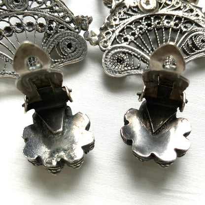 Silver filigree chandelier clip-on earrings with floral motifs and delicate openwork details.  シルバーのフィリグリー細工が施されたシャンデリア型クリップイヤリング。 