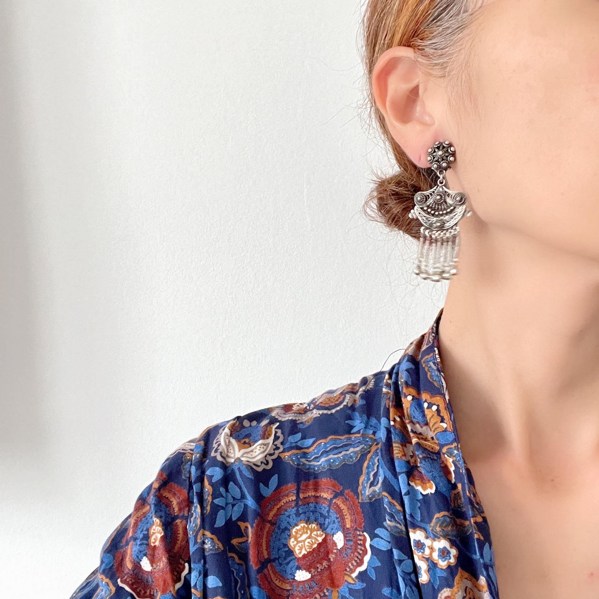 Silver filigree chandelier clip-on earrings with floral motifs and delicate openwork details.  シルバーのフィリグリー細工が施されたシャンデリア型クリップイヤリング。 