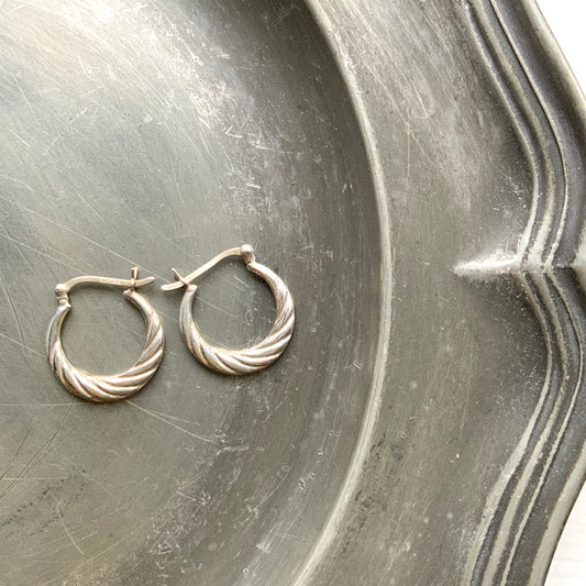 Silver hoop earrings with a twisted design.  シルバーのツイスト模様が入ったフープピアス。 