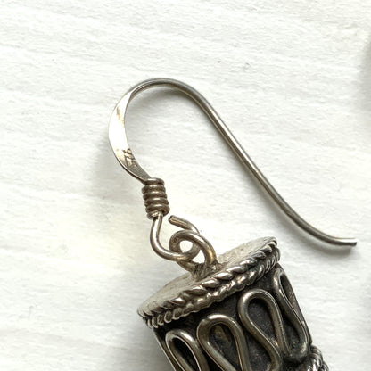 Silver spike-shaped earrings with tribal-inspired patterns.  トライバルな模様が入った細長いスパイク型のシルバーピアス。