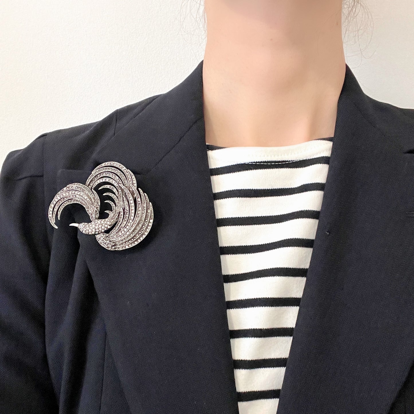A vintage bird brooch in silver-tone metal, defined by its flowing, sculptural lines. 流れるようなラインが印象的な、鳥モチーフのブローチ。