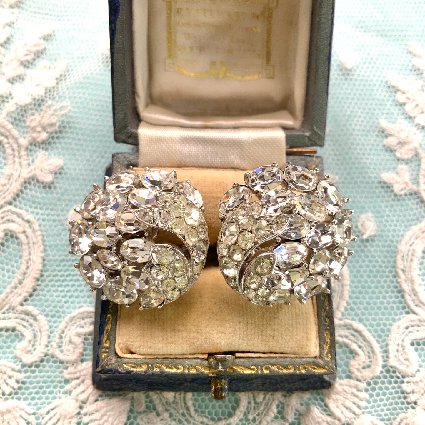 Round clip-on earrings by Trifari, set with clusters of clear rhinestones. クリアラインストーンが敷き詰められた、トリファリのラウンドイヤリング。