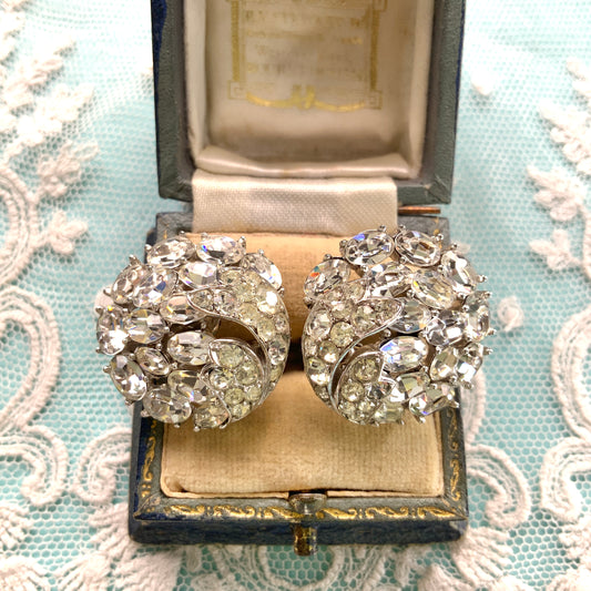 Round clip-on earrings by Trifari, set with clusters of clear rhinestones. クリアラインストーンが敷き詰められた、トリファリのラウンドイヤリング。