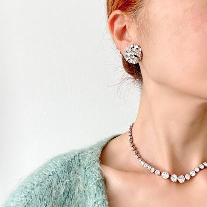 Round clip-on earrings by Trifari, set with clusters of clear rhinestones. クリアラインストーンが敷き詰められた、トリファリのラウンドイヤリング。