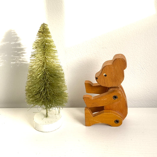 A sweet little wooden bear with wide, curious eyes and a simple, charming expression.キョロっとした目が愛らしい、木製の小さなクマのおもちゃ。