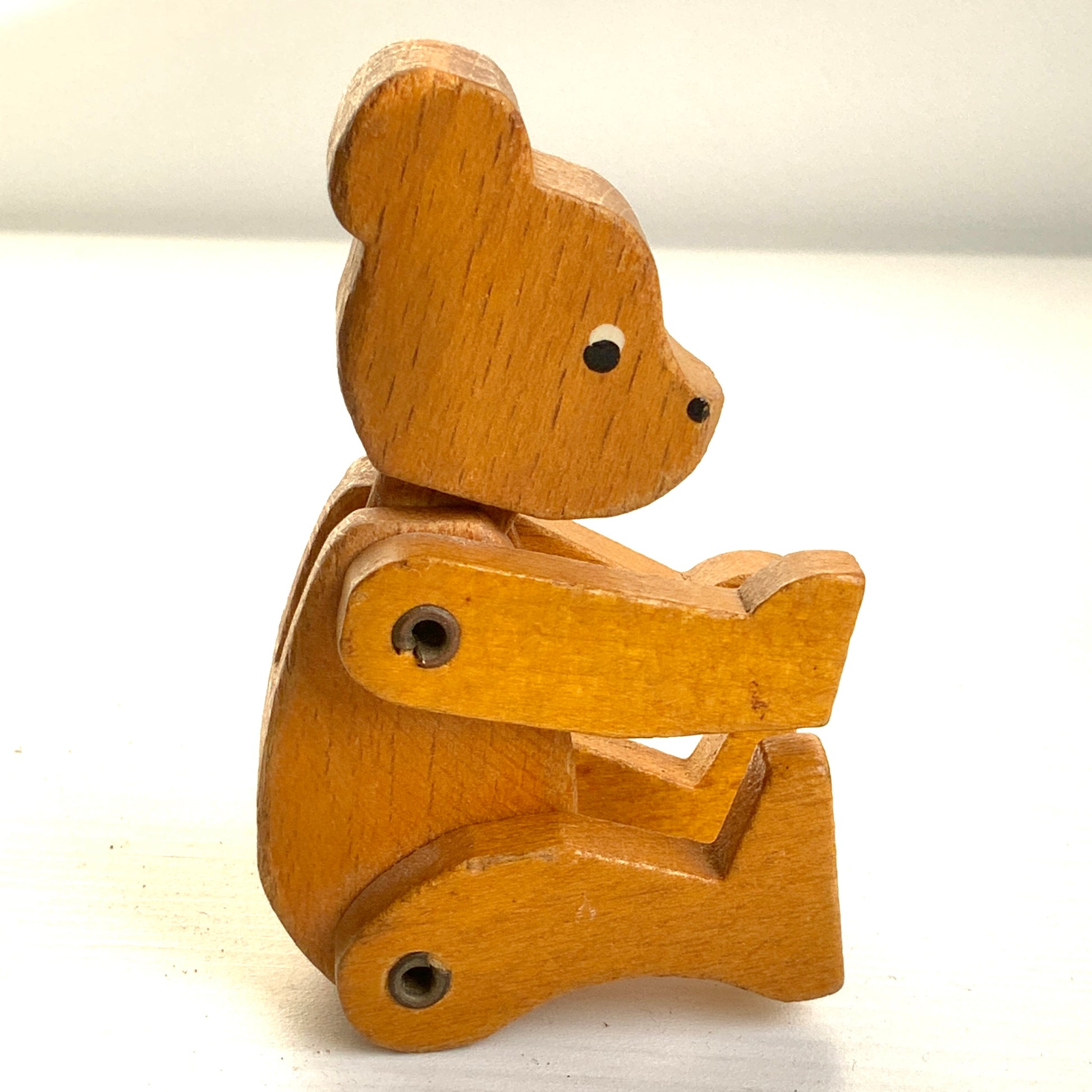 A sweet little wooden bear with wide, curious eyes and a simple, charming expression.キョロっとした目が愛らしい、木製の小さなクマのおもちゃ。
