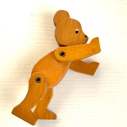 A sweet little wooden bear with wide, curious eyes and a simple, charming expression.キョロっとした目が愛らしい、木製の小さなクマのおもちゃ。