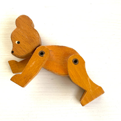 A sweet little wooden bear with wide, curious eyes and a simple, charming expression.キョロっとした目が愛らしい、木製の小さなクマのおもちゃ。