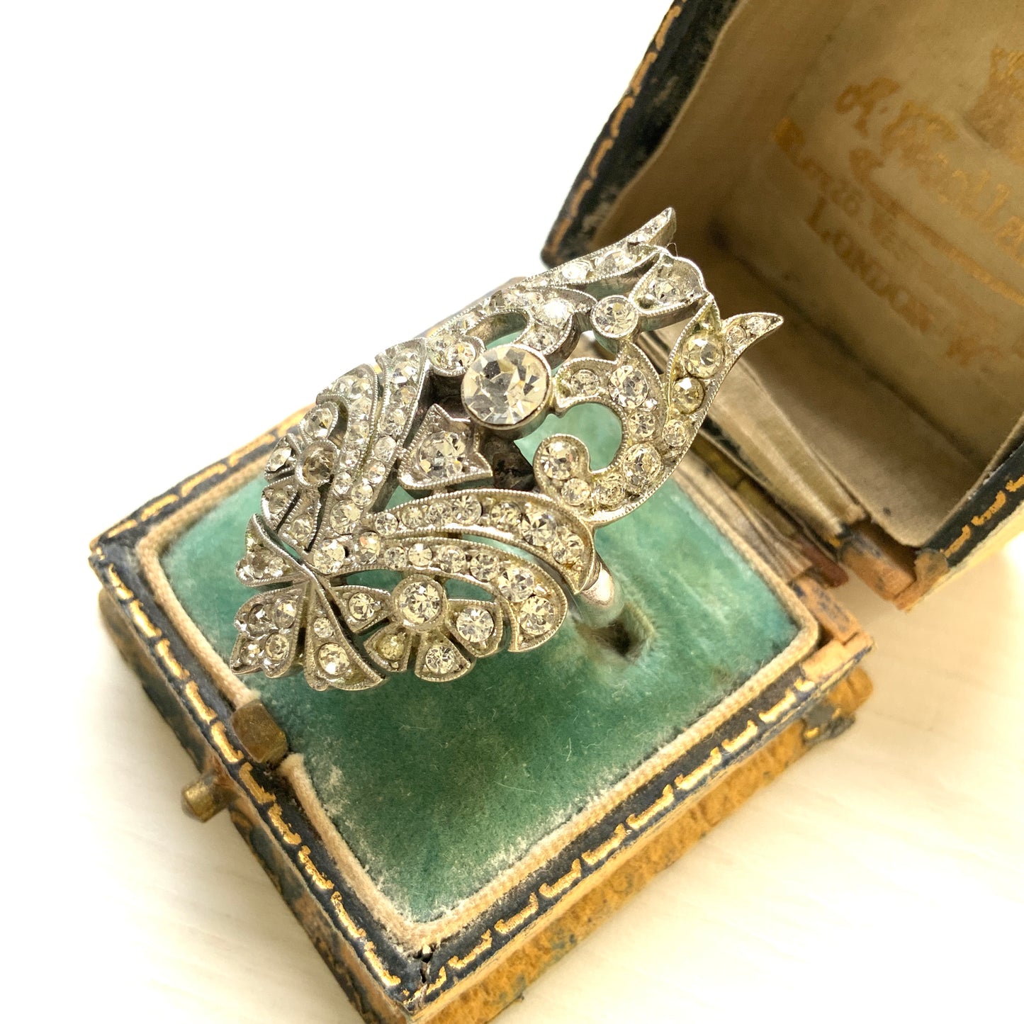 A striking vintage ring adorned with intricate scrollwork and densely set clear rhinestones. 細やかなスクロール装飾にクリアラインストーンがぎっしりと敷き詰められた、存在感たっぷりのヴィンテージリング。