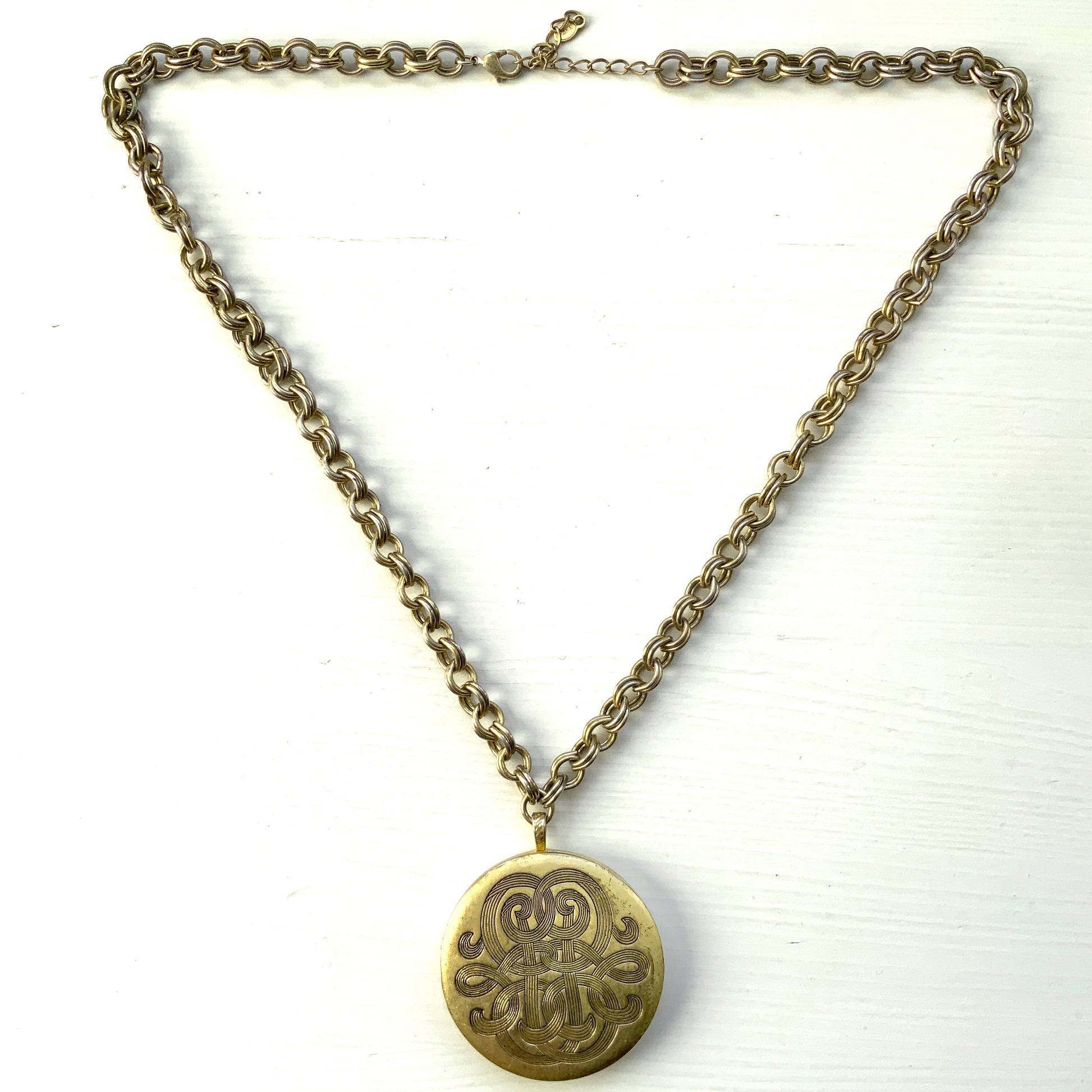 A vintage Monet locket necklace featuring an eye-catching woven-style scroll pattern.  編み込まれたような曲線模様が印象的な、Monet（モネ）のヴィンテージロケットネックレス。