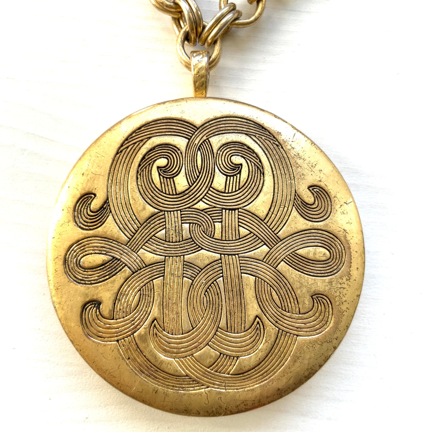 A vintage Monet locket necklace featuring an eye-catching woven-style scroll pattern.  編み込まれたような曲線模様が印象的な、Monet（モネ）のヴィンテージロケットネックレス。