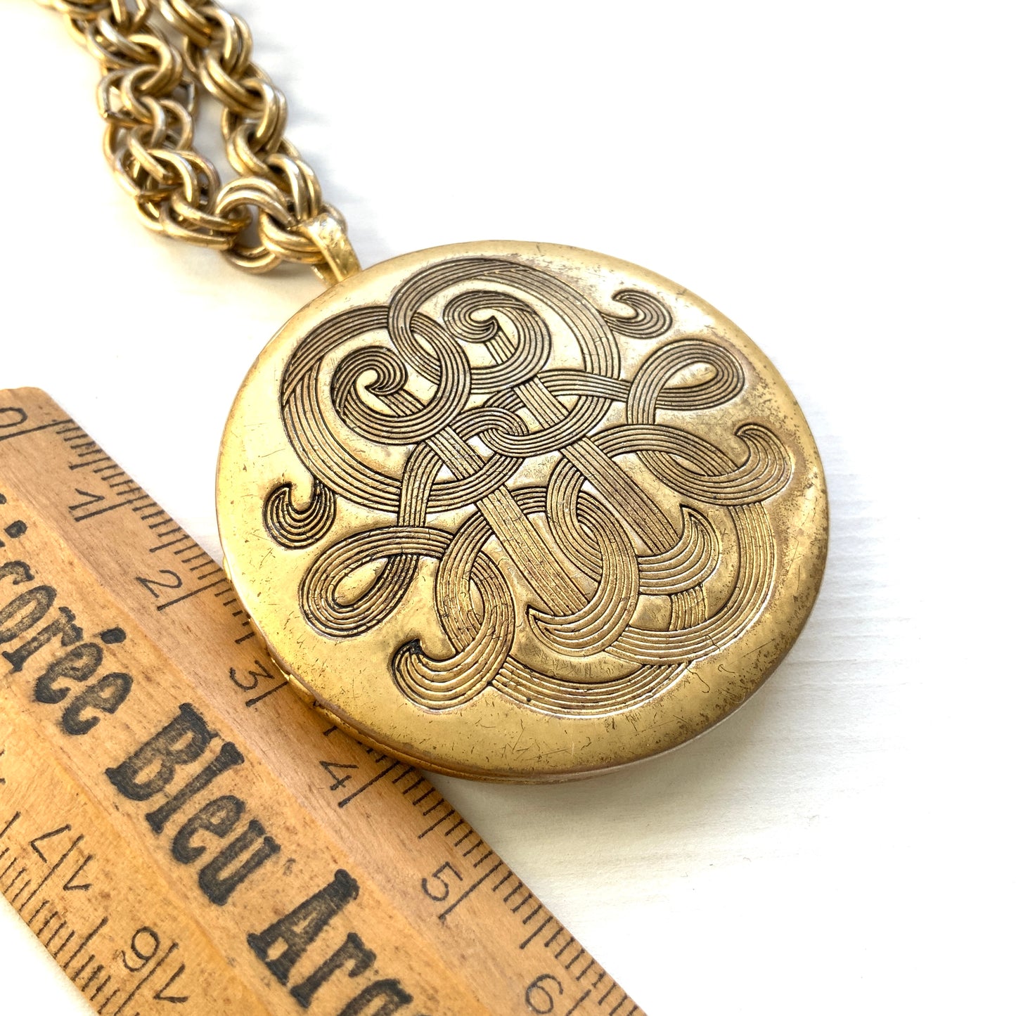 A vintage Monet locket necklace featuring an eye-catching woven-style scroll pattern.  編み込まれたような曲線模様が印象的な、Monet（モネ）のヴィンテージロケットネックレス。