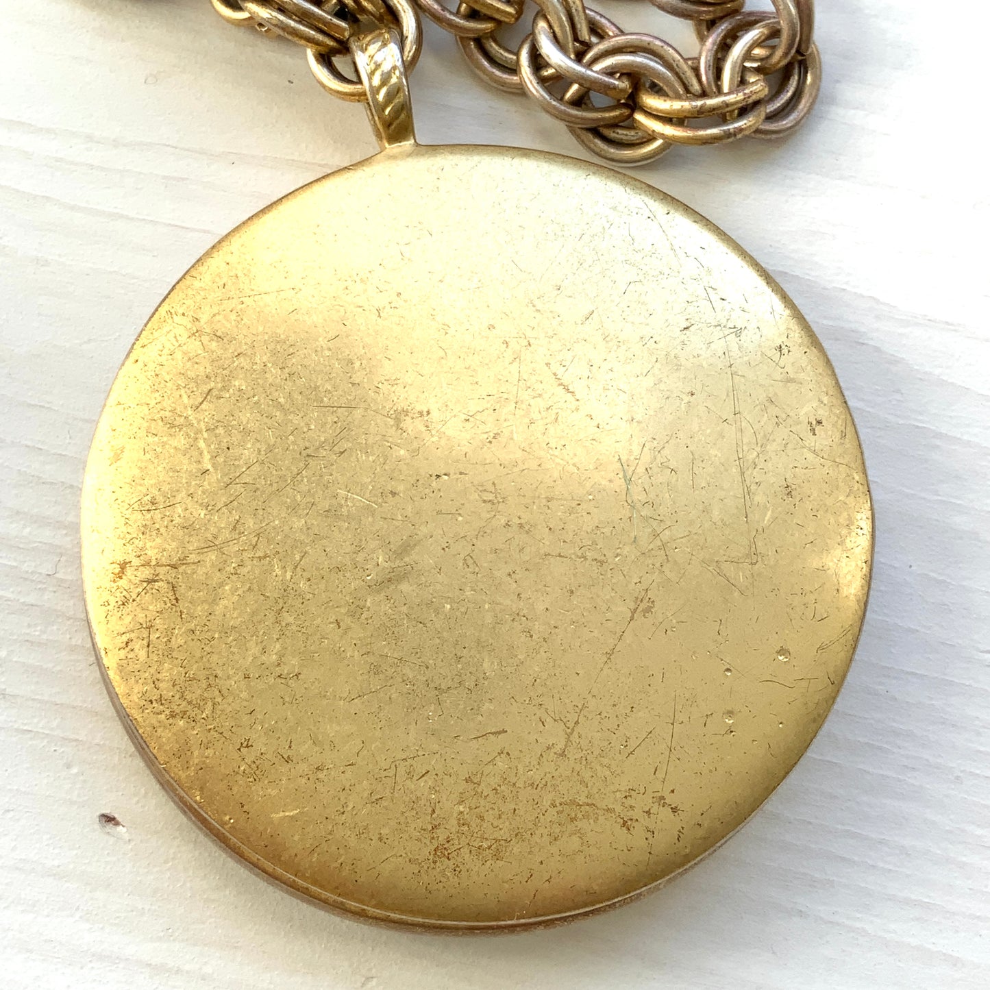 A vintage Monet locket necklace featuring an eye-catching woven-style scroll pattern.  編み込まれたような曲線模様が印象的な、Monet（モネ）のヴィンテージロケットネックレス。