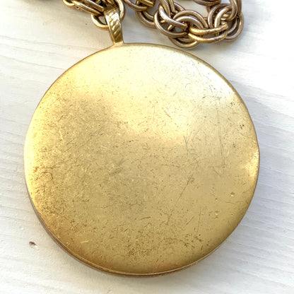 A vintage Monet locket necklace featuring an eye-catching woven-style scroll pattern.  編み込まれたような曲線模様が印象的な、Monet（モネ）のヴィンテージロケットネックレス。