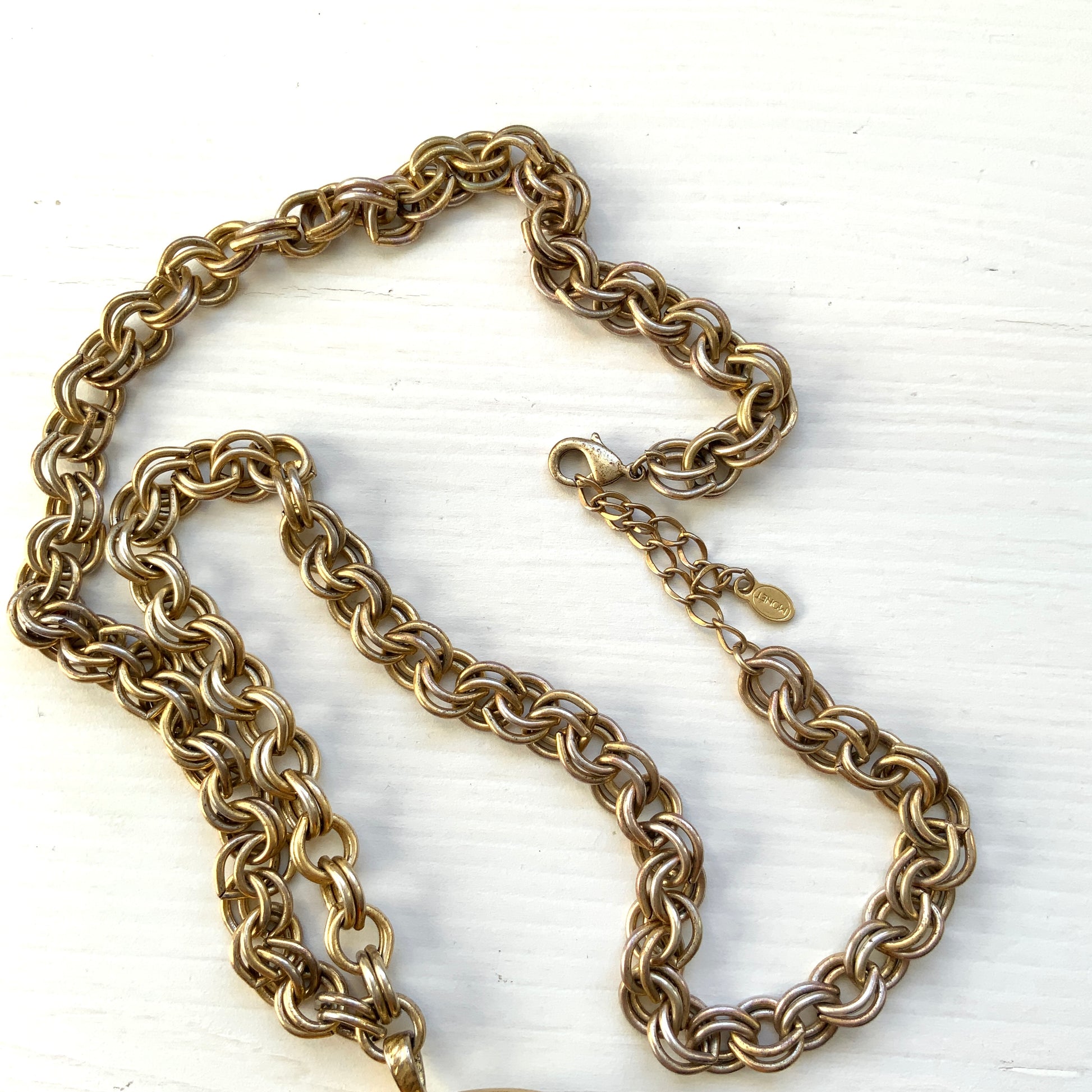 A vintage Monet locket necklace featuring an eye-catching woven-style scroll pattern.  編み込まれたような曲線模様が印象的な、Monet（モネ）のヴィンテージロケットネックレス。