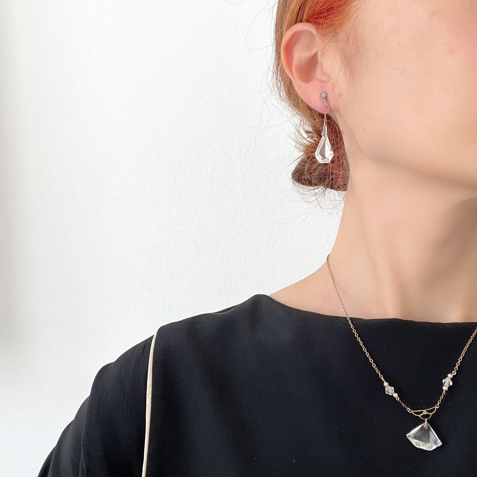 Screw-back earrings featuring clear faceted glass in a unique triangular form. ユニークな三角フォルムのファセットグラスが揺れる、スクリューイヤリング。