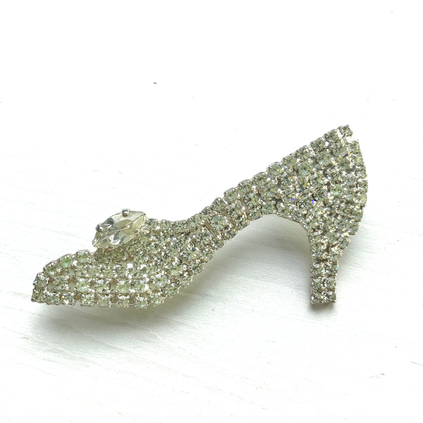A vintage brooch shaped like a “glass slipper”, set with sparkling clear rhinestones throughout. ラインストーンがびっしりと敷き詰められた“ガラスの靴”のようなヴィンテージブローチ。 