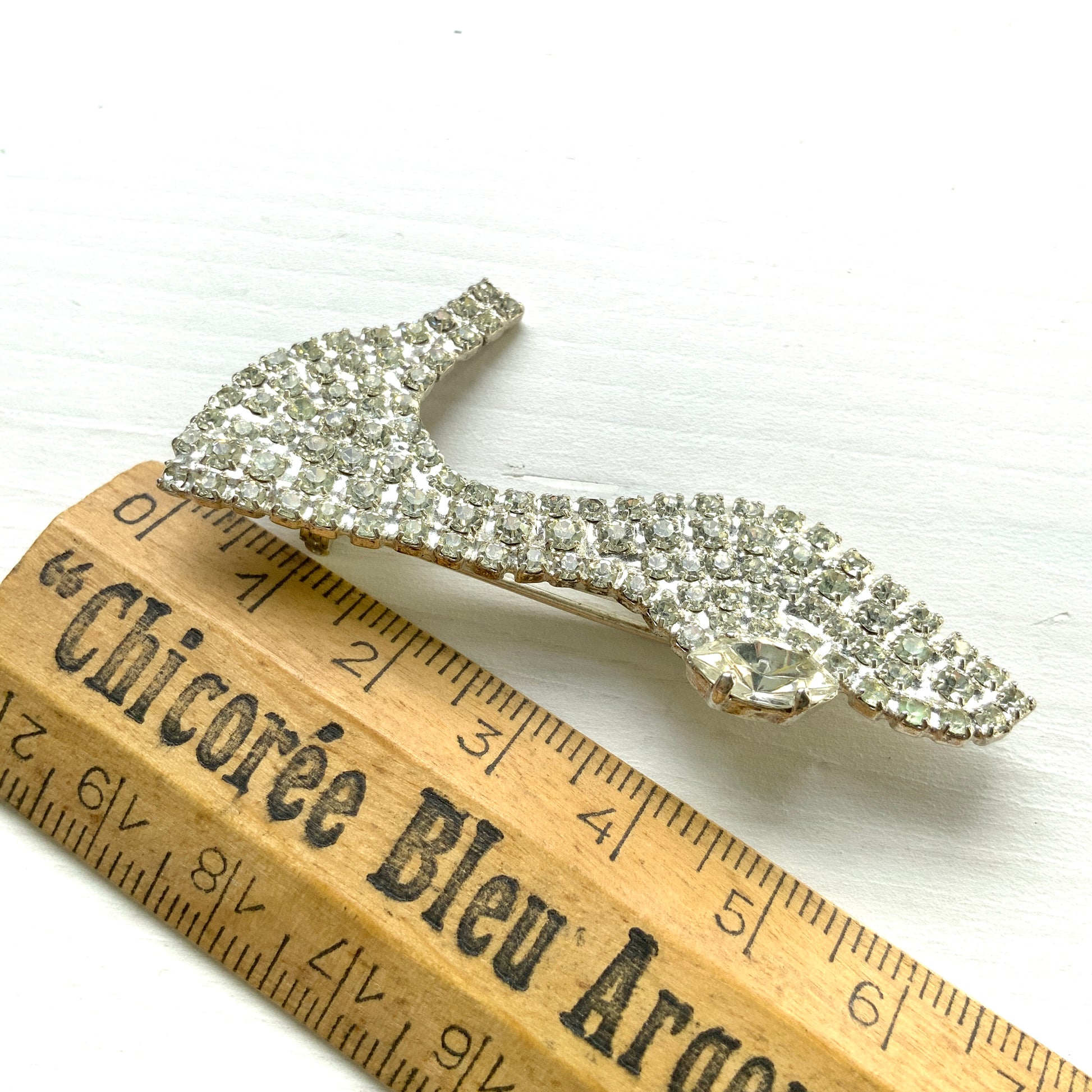 A vintage brooch shaped like a “glass slipper”, set with sparkling clear rhinestones throughout. ラインストーンがびっしりと敷き詰められた“ガラスの靴”のようなヴィンテージブローチ。 