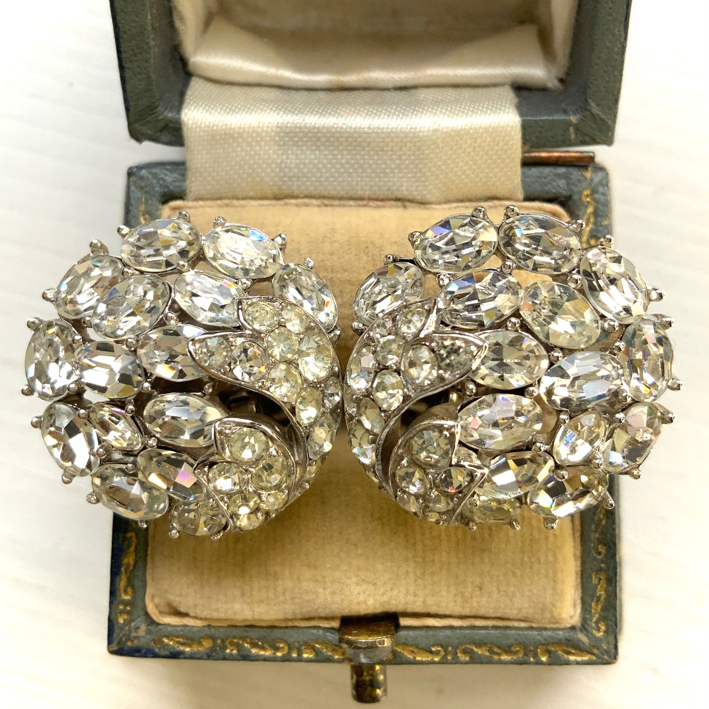 Round clip-on earrings by Trifari, set with clusters of clear rhinestones. クリアラインストーンが敷き詰められた、トリファリのラウンドイヤリング。