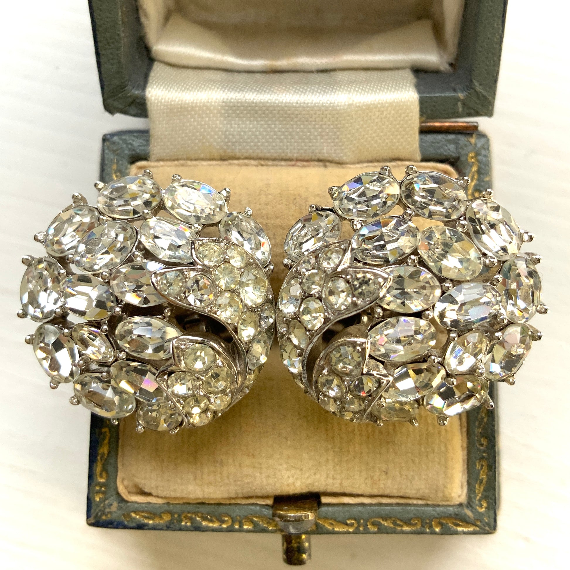 Round clip-on earrings by Trifari, set with clusters of clear rhinestones. クリアラインストーンが敷き詰められた、トリファリのラウンドイヤリング。