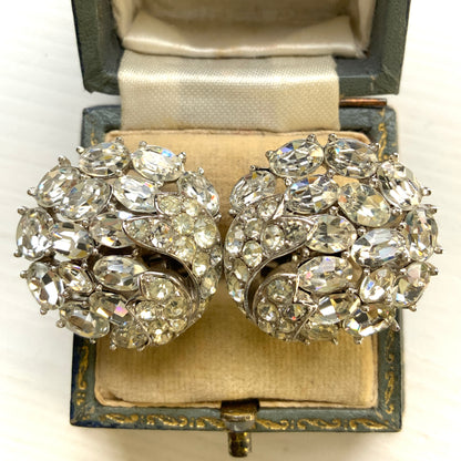 Round clip-on earrings by Trifari, set with clusters of clear rhinestones. クリアラインストーンが敷き詰められた、トリファリのラウンドイヤリング。