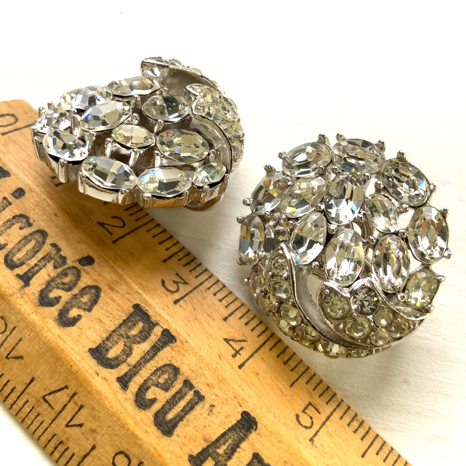 Round clip-on earrings by Trifari, set with clusters of clear rhinestones. クリアラインストーンが敷き詰められた、トリファリのラウンドイヤリング。