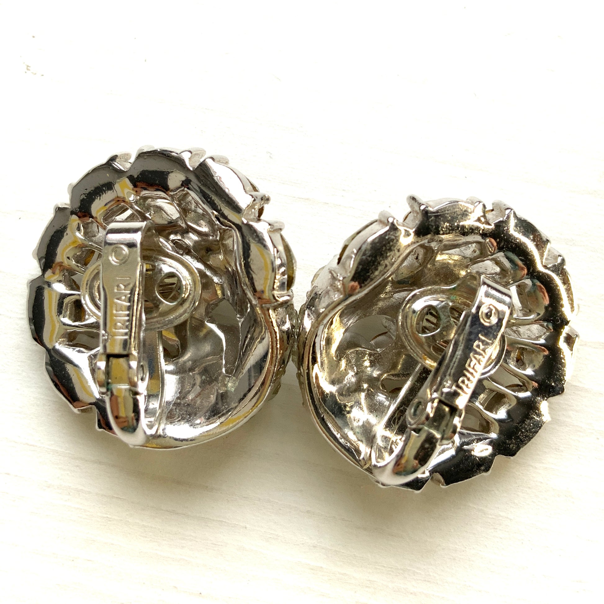 Round clip-on earrings by Trifari, set with clusters of clear rhinestones. クリアラインストーンが敷き詰められた、トリファリのラウンドイヤリング。