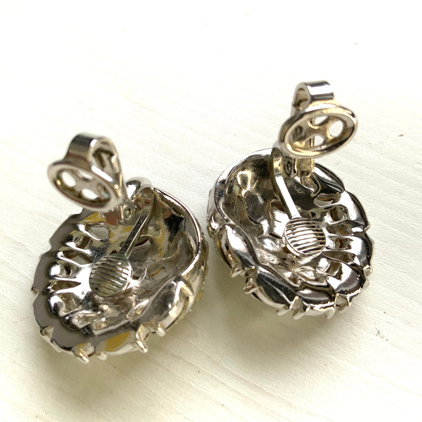 Round clip-on earrings by Trifari, set with clusters of clear rhinestones. クリアラインストーンが敷き詰められた、トリファリのラウンドイヤリング。