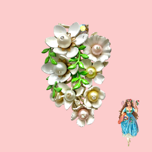 Vintage 1950s brooch featuring white enamel flowers adorned with soft pastel-coloured pearls. ホワイトエナメルの花に淡いパステルカラーのパールがあしらわれた、1950年代のヴィンテージブローチ。