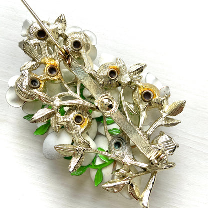 Vintage 1950s brooch featuring white enamel flowers adorned with soft pastel-coloured pearls. ホワイトエナメルの花に淡いパステルカラーのパールがあしらわれた、1950年代のヴィンテージブローチ。