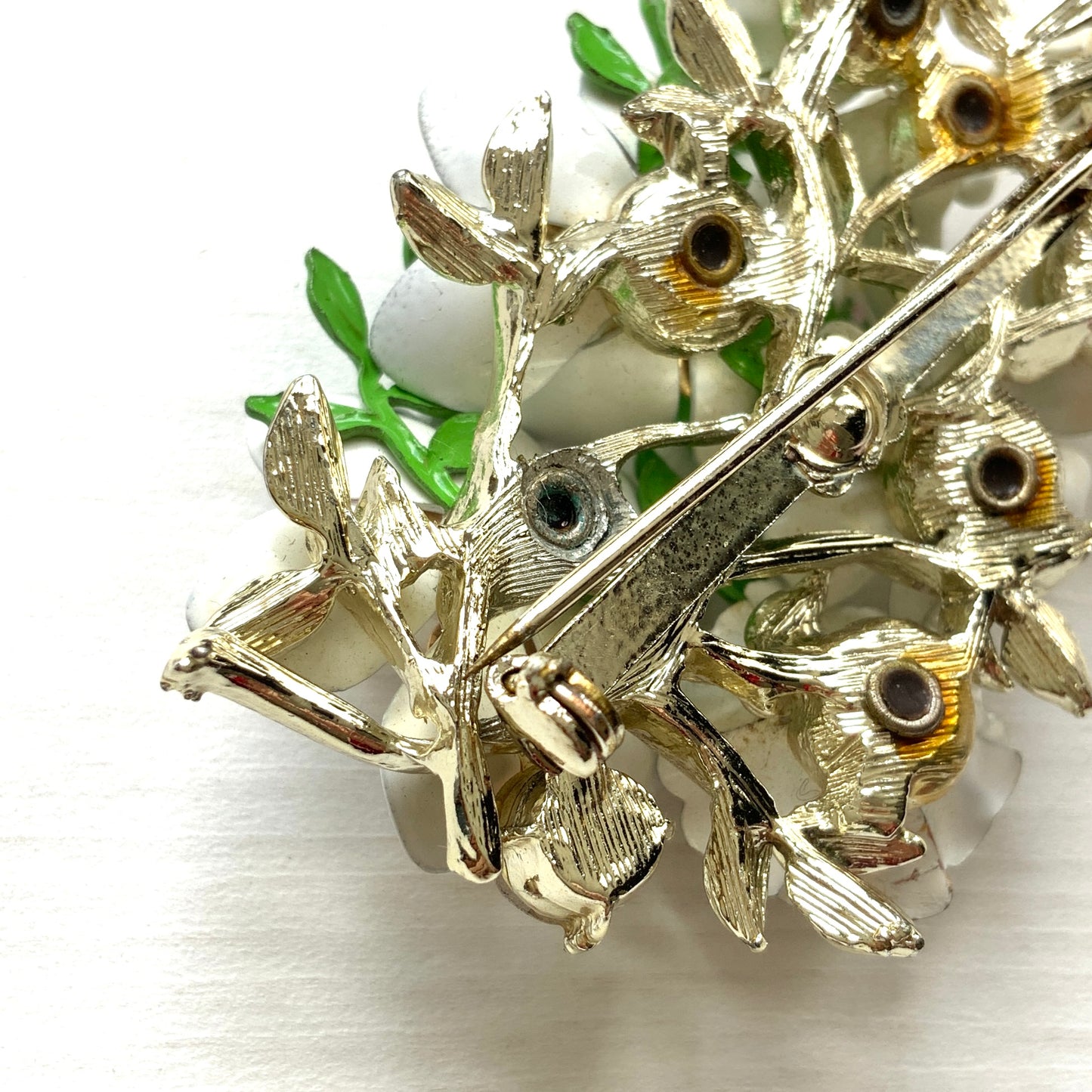 Vintage 1950s brooch featuring white enamel flowers adorned with soft pastel-coloured pearls. ホワイトエナメルの花に淡いパステルカラーのパールがあしらわれた、1950年代のヴィンテージブローチ。