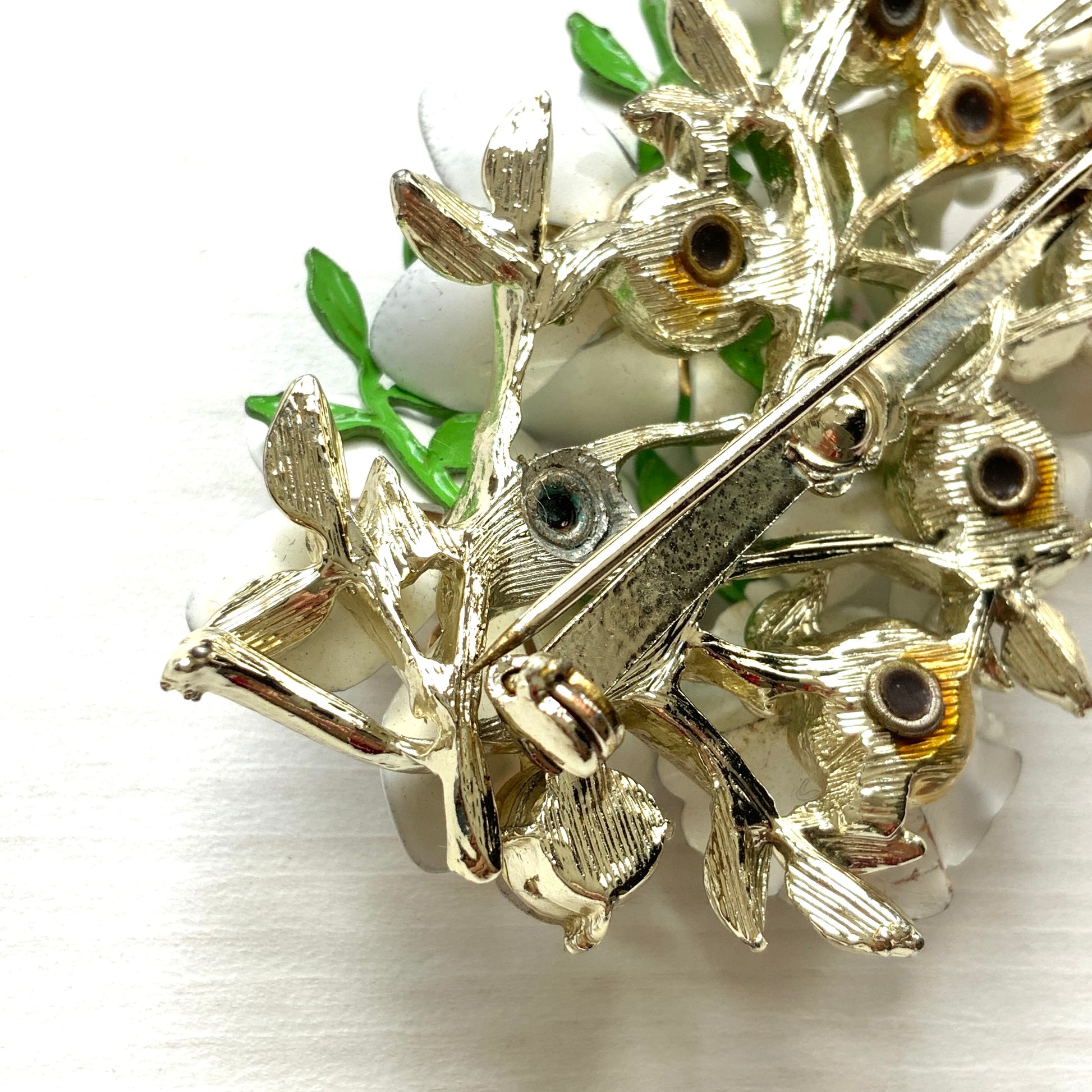 Vintage 1950s brooch featuring white enamel flowers adorned with soft pastel-coloured pearls. ホワイトエナメルの花に淡いパステルカラーのパールがあしらわれた、1950年代のヴィンテージブローチ。