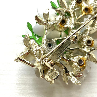 Vintage 1950s brooch featuring white enamel flowers adorned with soft pastel-coloured pearls. ホワイトエナメルの花に淡いパステルカラーのパールがあしらわれた、1950年代のヴィンテージブローチ。