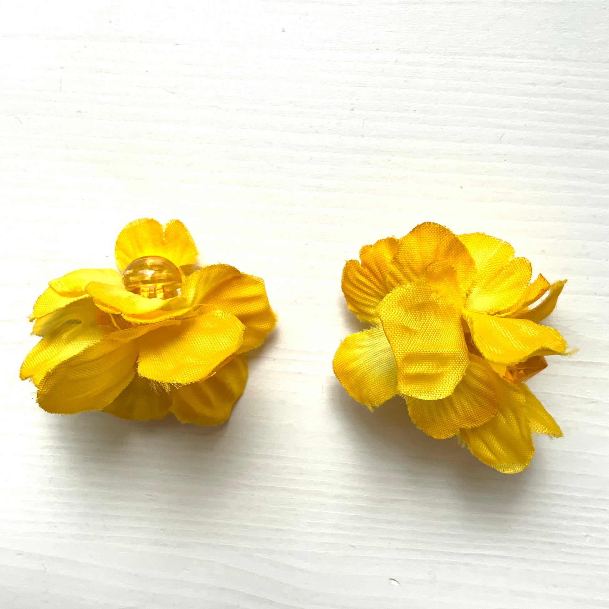 Vintage clip-on earrings featuring bright yellow fabric flowers. ぱっと明るいイエローの布花を使ったヴィンテージのクリップイヤリング。