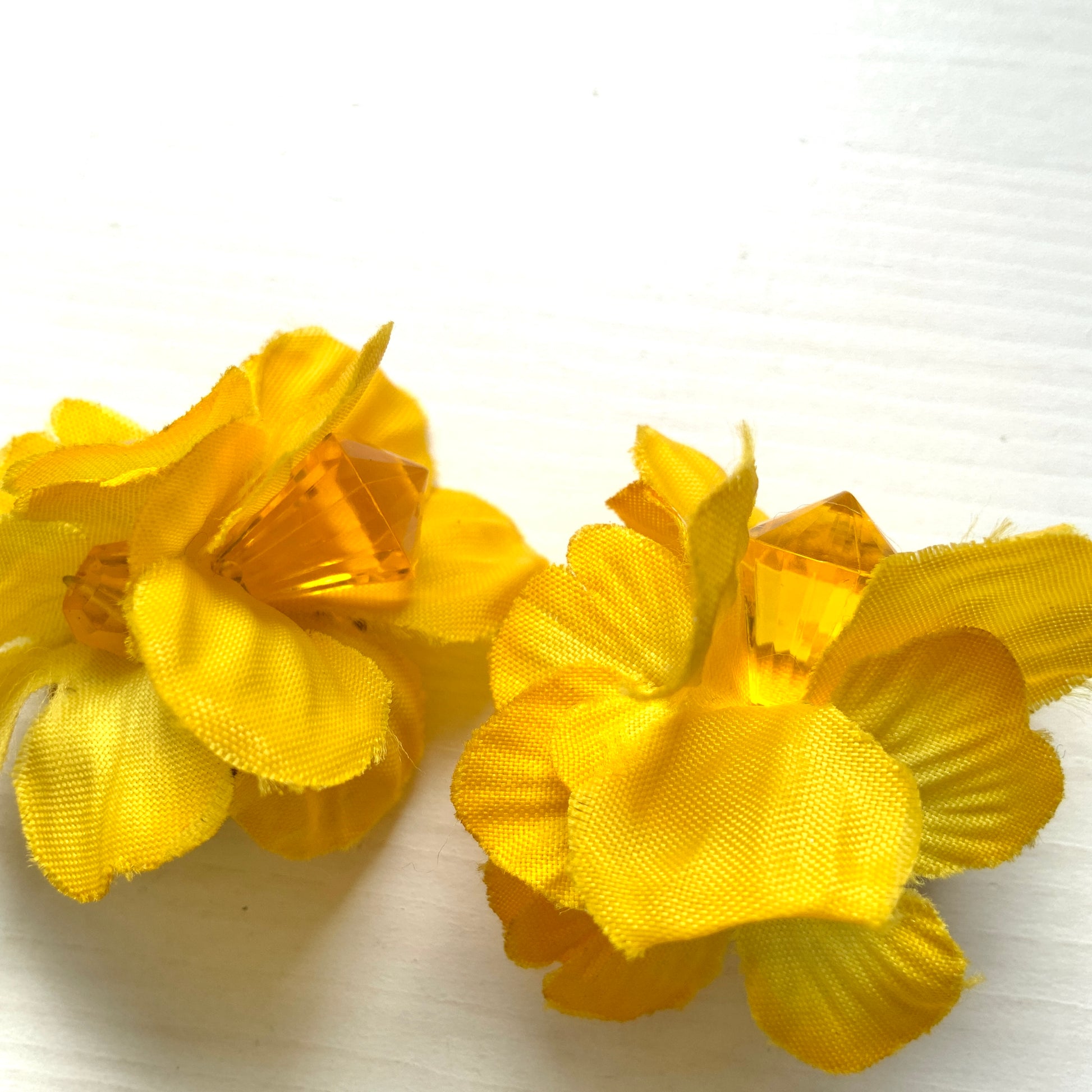 Vintage clip-on earrings featuring bright yellow fabric flowers. ぱっと明るいイエローの布花を使ったヴィンテージのクリップイヤリング。