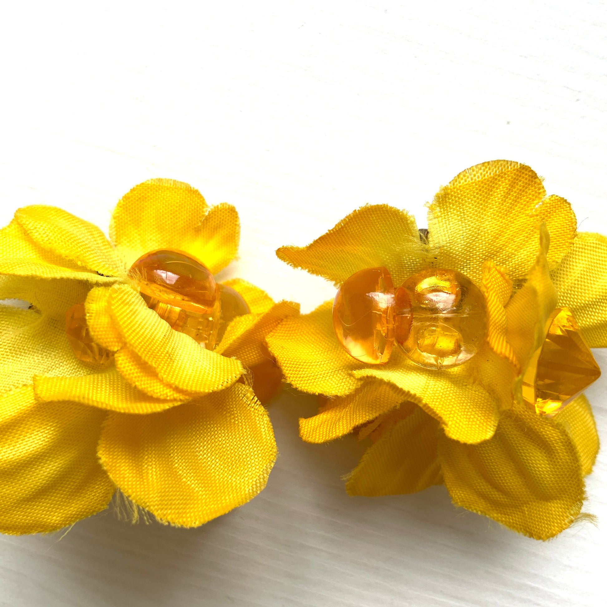Vintage clip-on earrings featuring bright yellow fabric flowers. ぱっと明るいイエローの布花を使ったヴィンテージのクリップイヤリング。