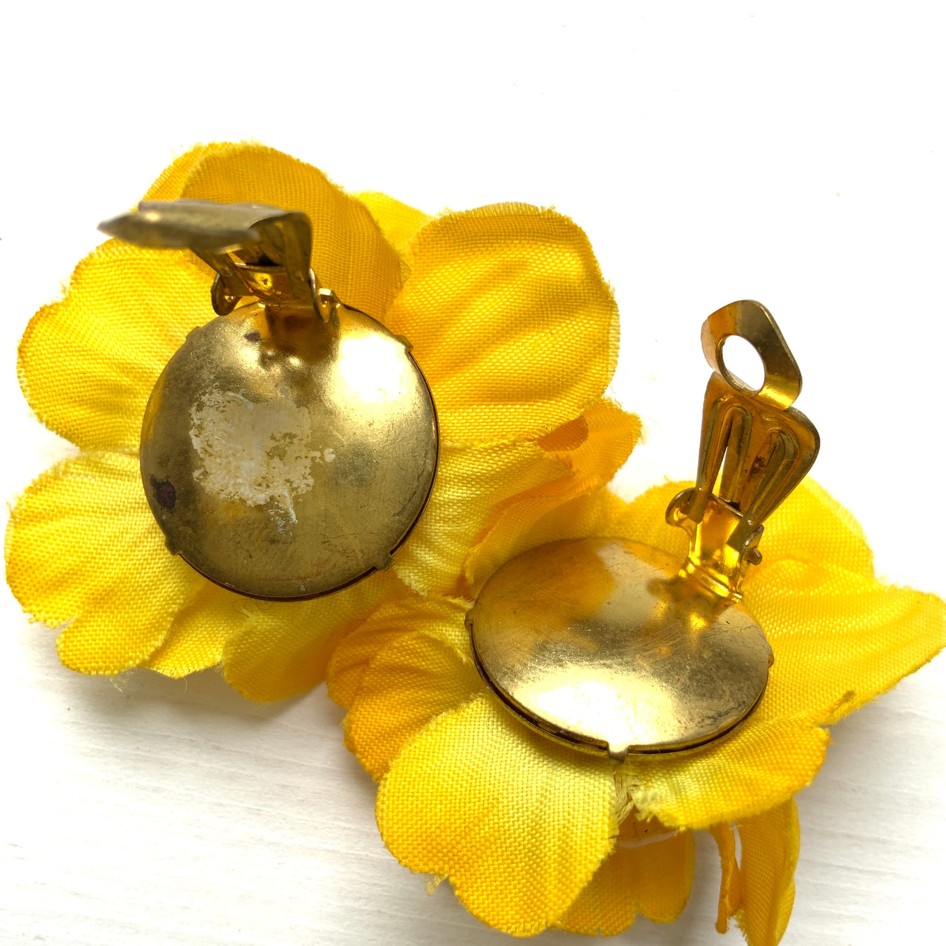 Vintage clip-on earrings featuring bright yellow fabric flowers. ぱっと明るいイエローの布花を使ったヴィンテージのクリップイヤリング。