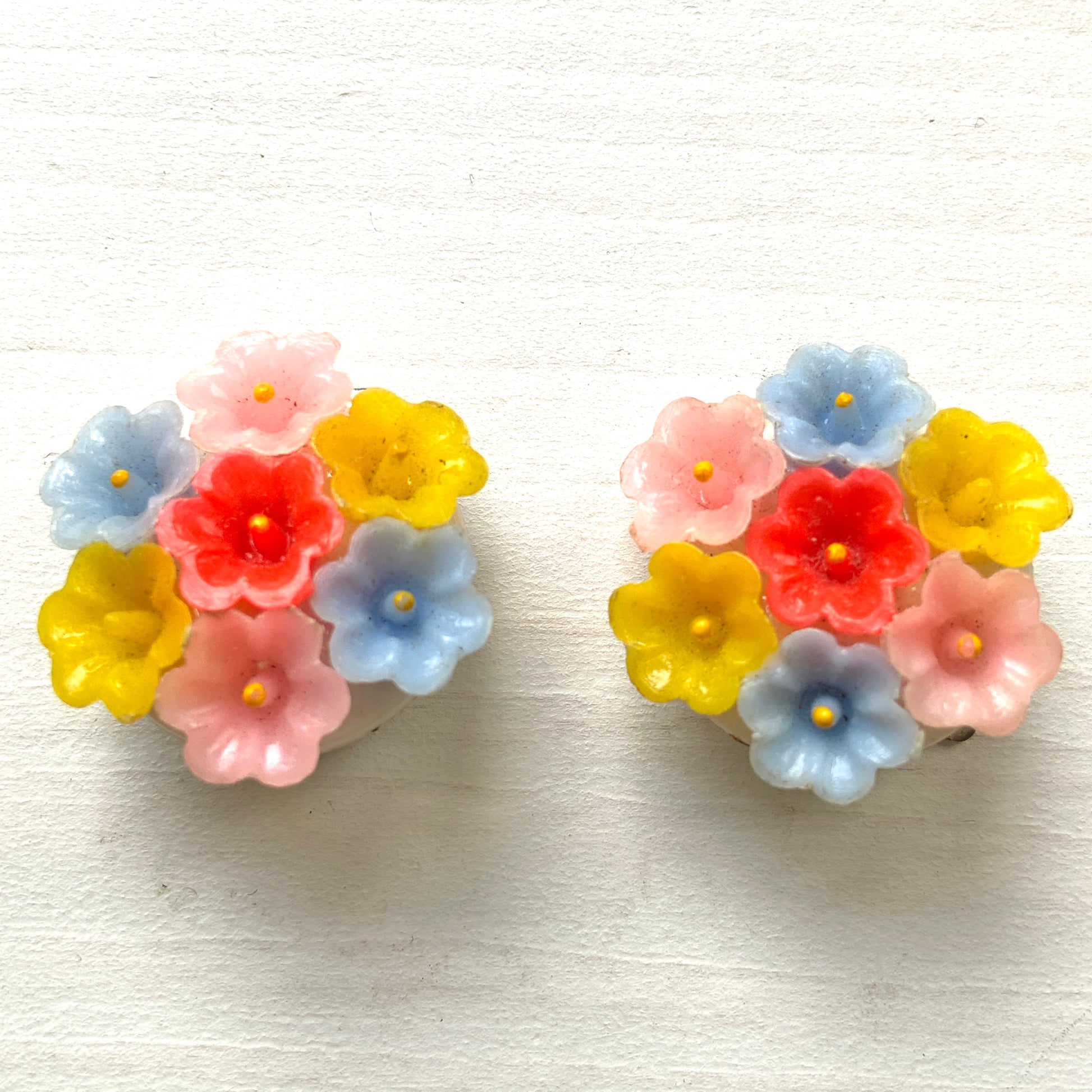Vintage 1960s clip-on earrings featuring a cluster of colourful plastic flowers. カラフルな小さなプラスチックフラワーが集まった、1960年代のヴィンテージクリップイヤリング。