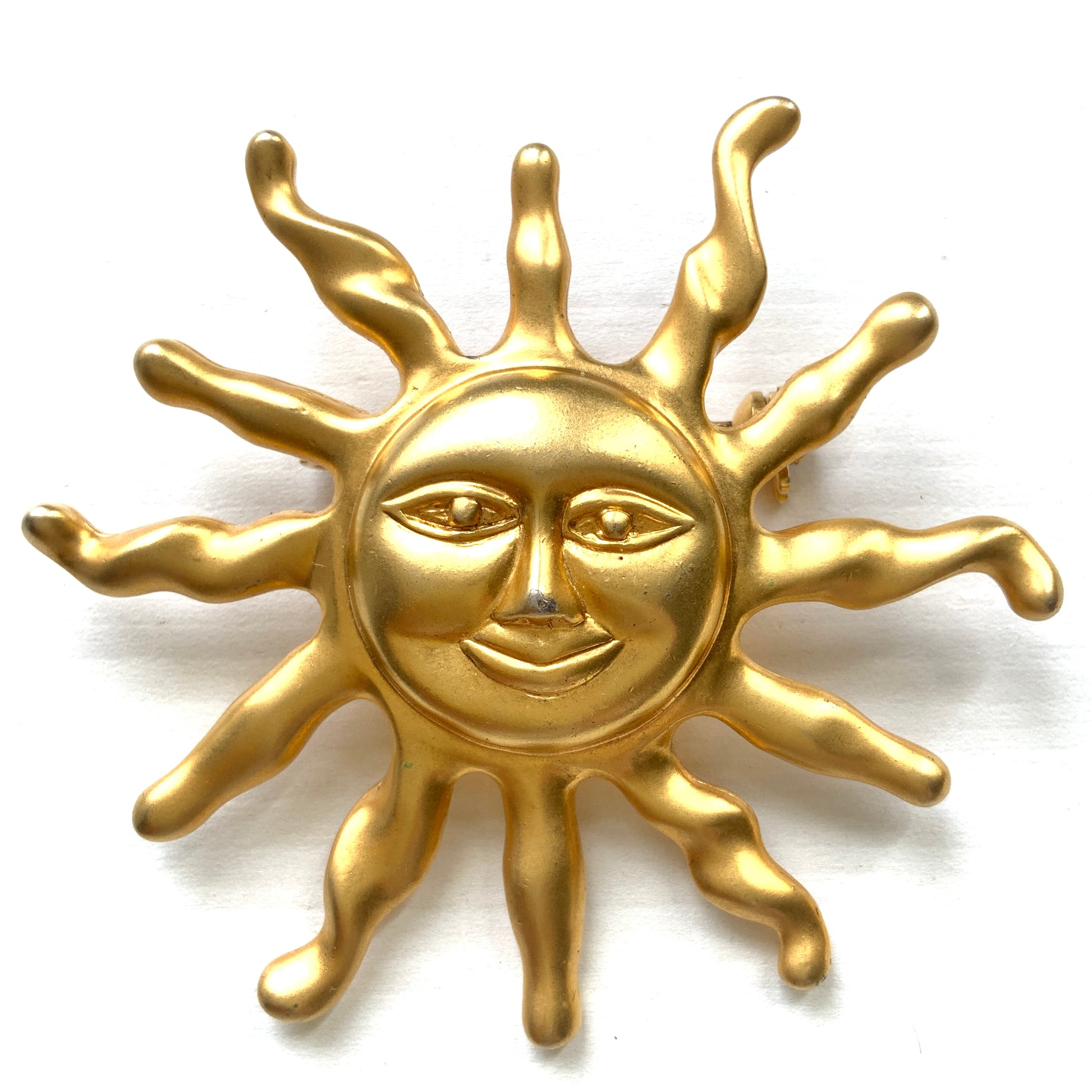 A charming vintage sun brooch featuring a smiling golden face. 微笑みをたたえたゴールドトーンの太陽が印象的なヴィンテージブローチ。