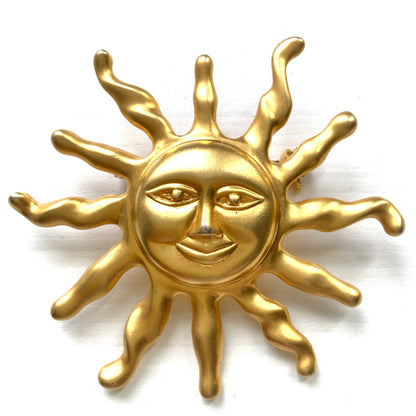 A charming vintage sun brooch featuring a smiling golden face. 微笑みをたたえたゴールドトーンの太陽が印象的なヴィンテージブローチ。
