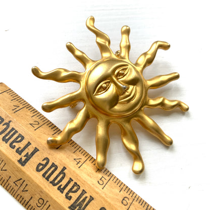 A charming vintage sun brooch featuring a smiling golden face. 微笑みをたたえたゴールドトーンの太陽が印象的なヴィンテージブローチ。