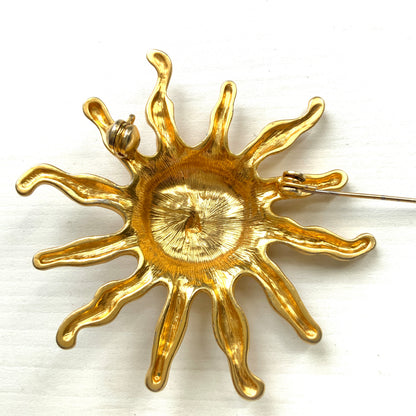 A charming vintage sun brooch featuring a smiling golden face. 微笑みをたたえたゴールドトーンの太陽が印象的なヴィンテージブローチ。